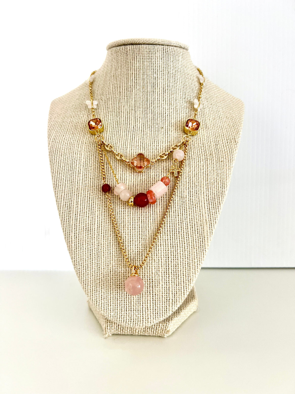 Gold-plated layered necklace with green crystal connectors, amber clover, cubic zirconia cross and aventurine ball charm