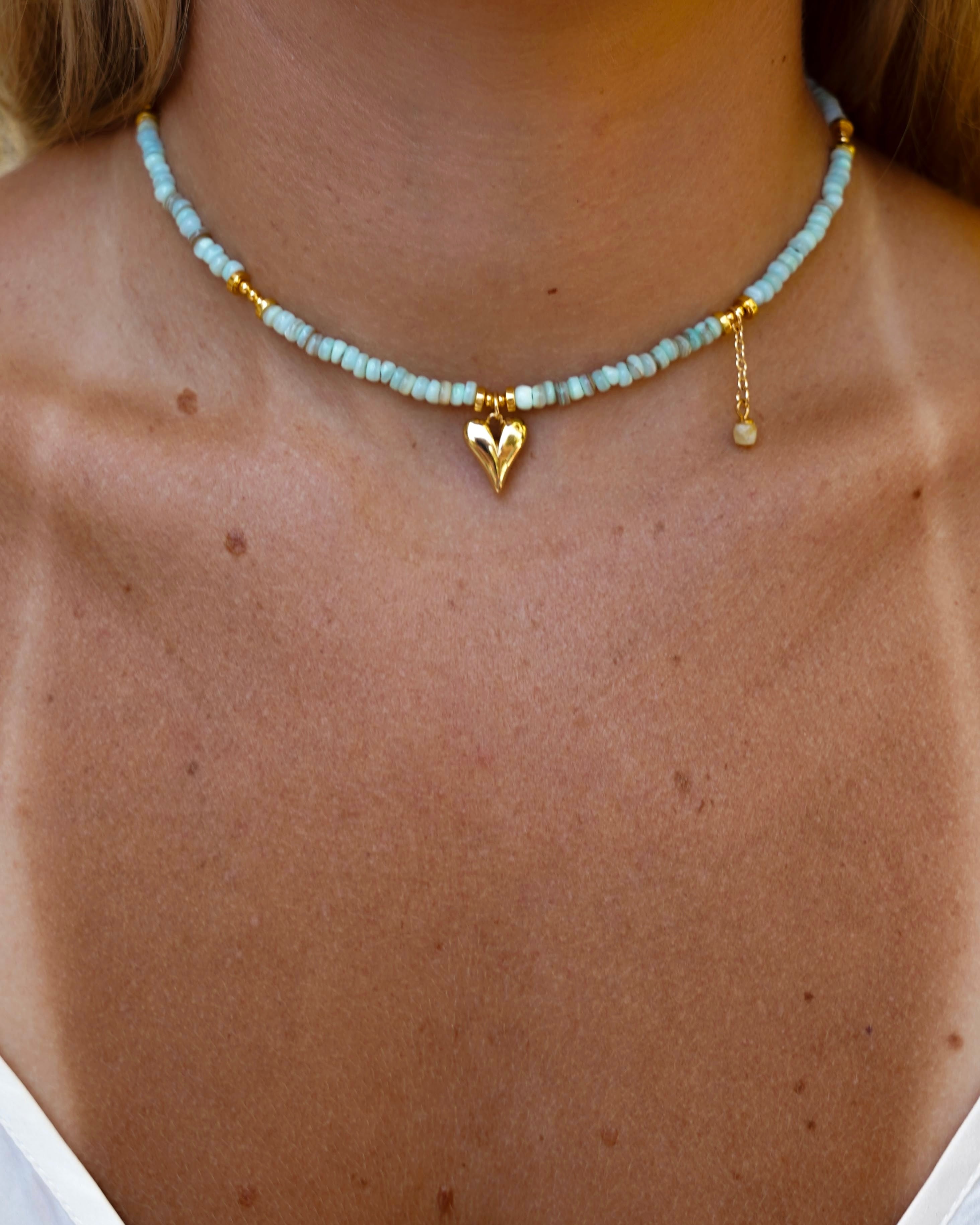 Necklace with heart pendant on a person wearing a white top