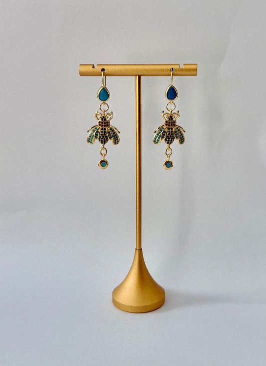 Gold-tone beetle earrings with deep teal teardrop studs, turquoise and dark-toned accents, and round turquoise-coloured drops