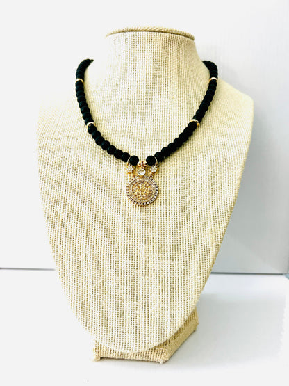 Black onyx beaded necklace with faceted beads and a cubic zirconia pavé coin pendant