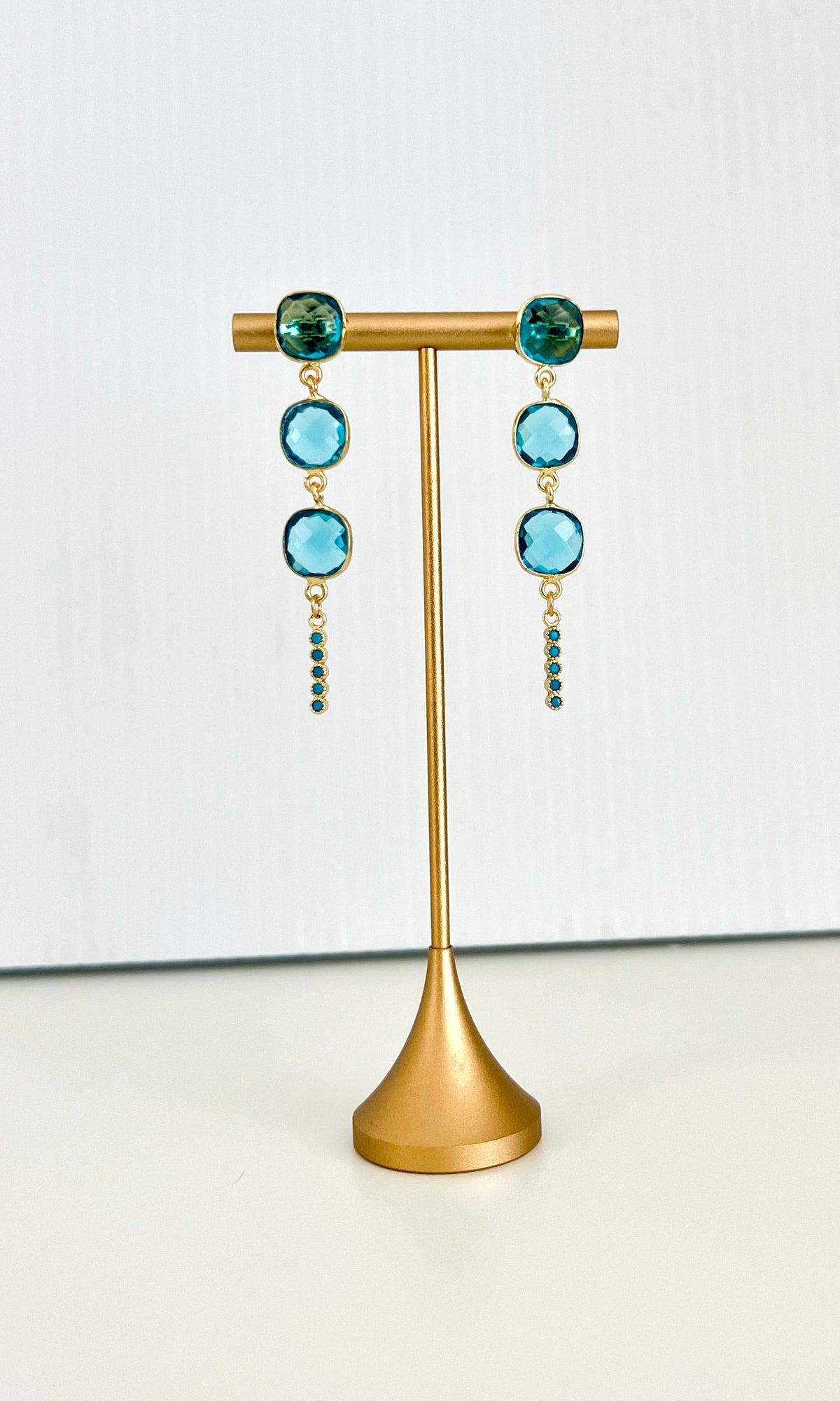 Long cushion-cut blue drop earrings with bezel settings and a turquoise bar detail